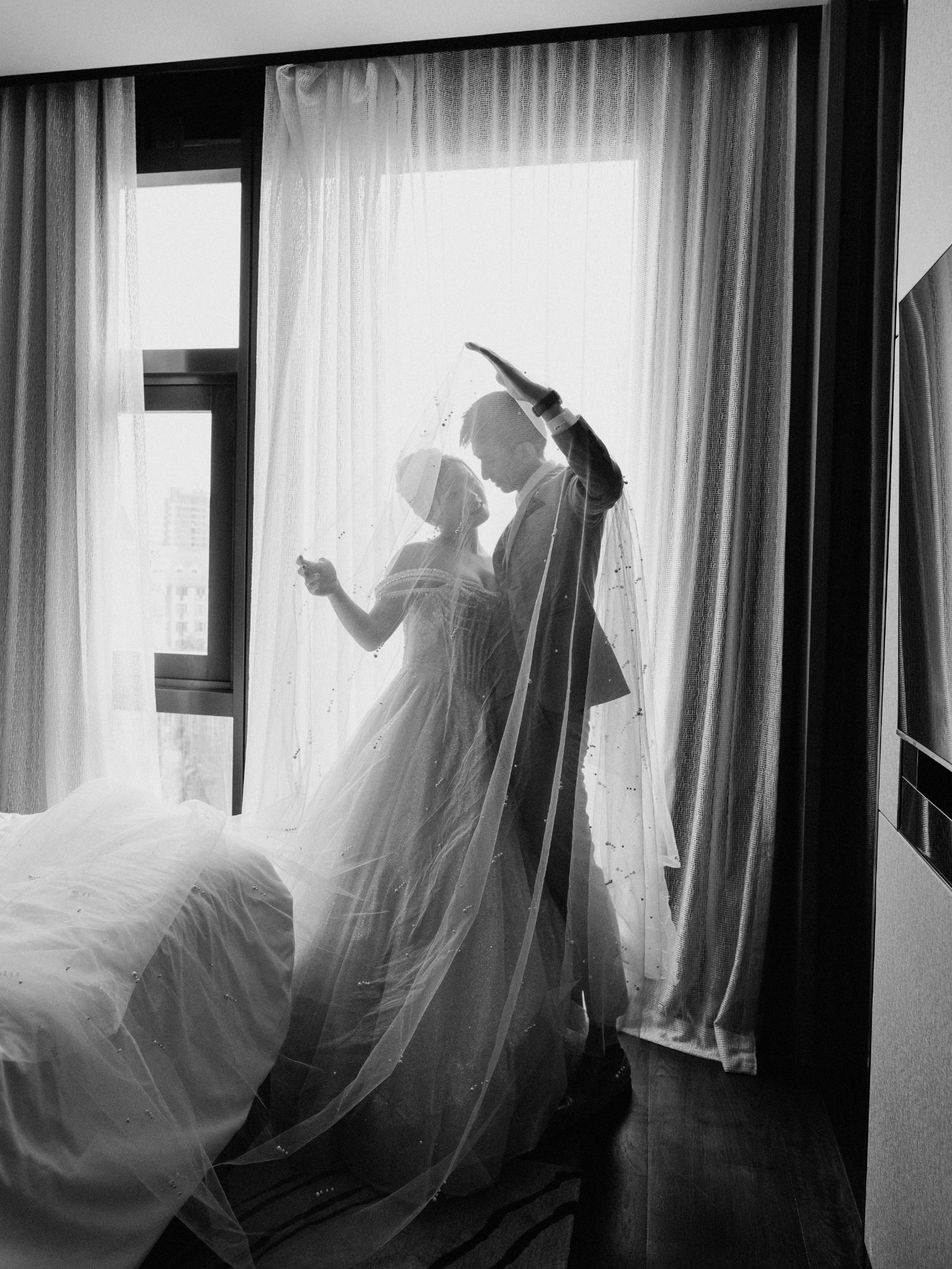 Wedding couple dancing by the window